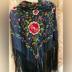 Floral crocheted shawl with long fringe.